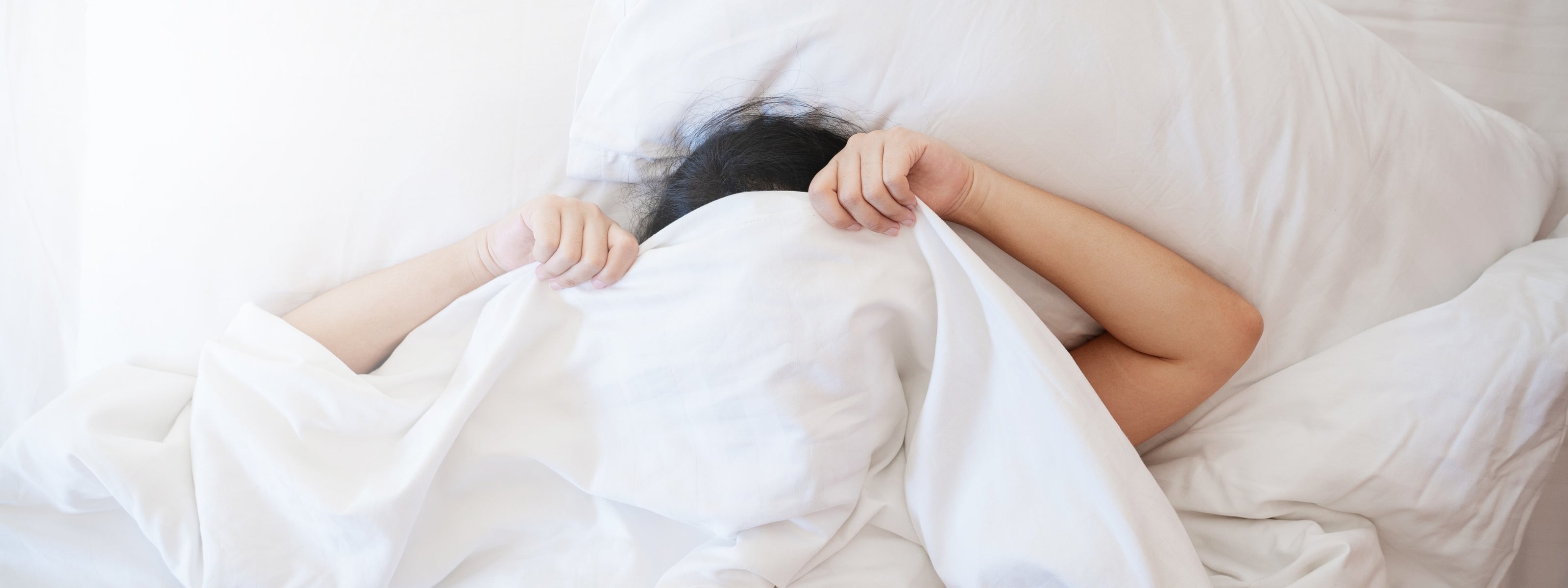 Luxury breathable cotton bedsheets in a minimalist white bedroom